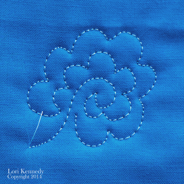 Flower design quilted on blue fabric