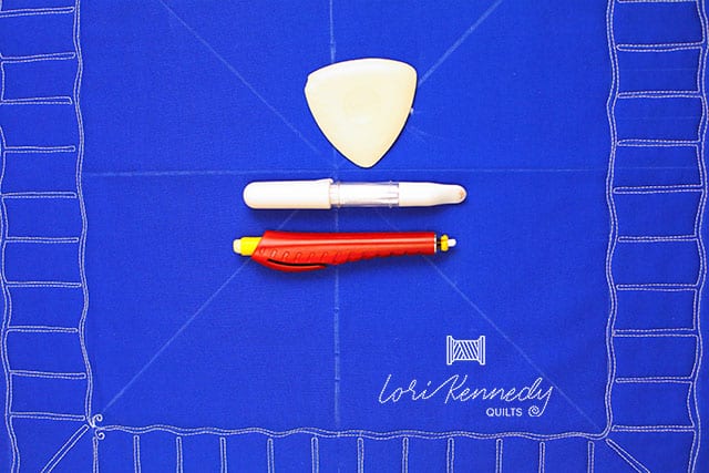 Pen and sewing markers on top of blue fabric