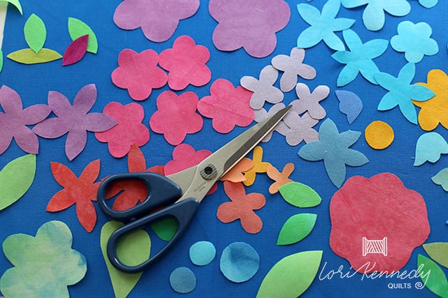 A pair of scissors sitting on top of a table with flower cutouts