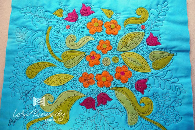 A close up of a piece of cloth with quilted flowers on it