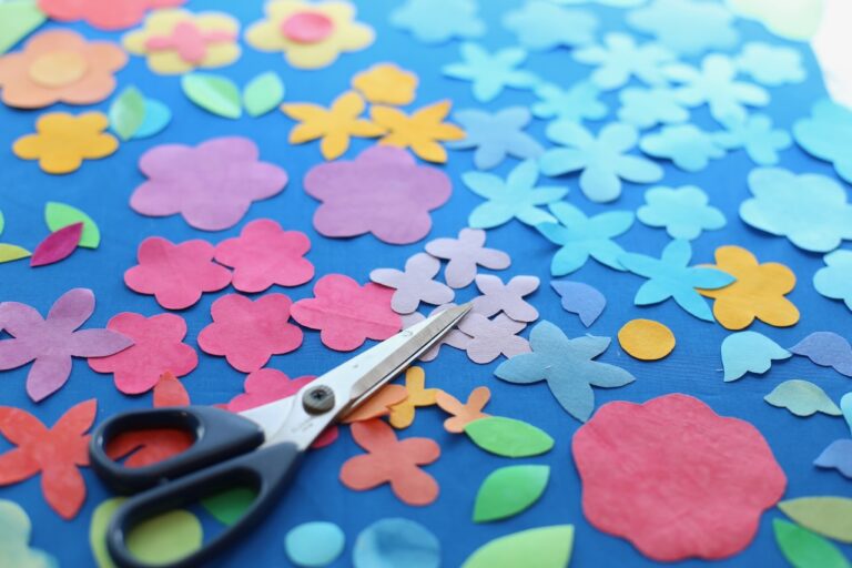 Paper cutouts of flowers with scissors